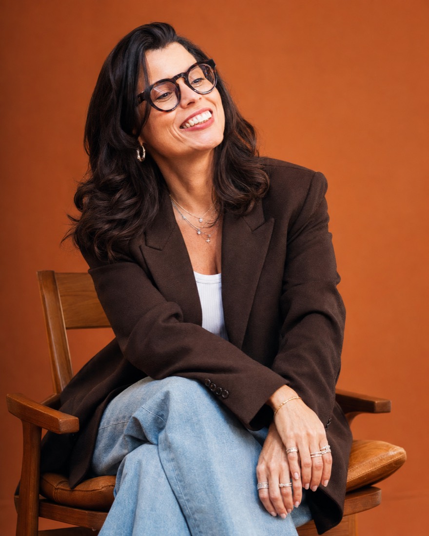 Rita Grassi sorrindo, sentada